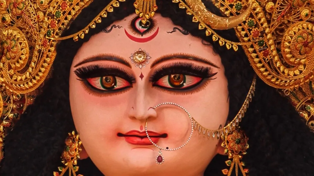 জগদ্ধাত্রী প্রতিমার মুখ, কাছ থেকে: কপালে তৃতীয় নয়ন, মাথায় সোনালি মুকুট, নাকে নথ